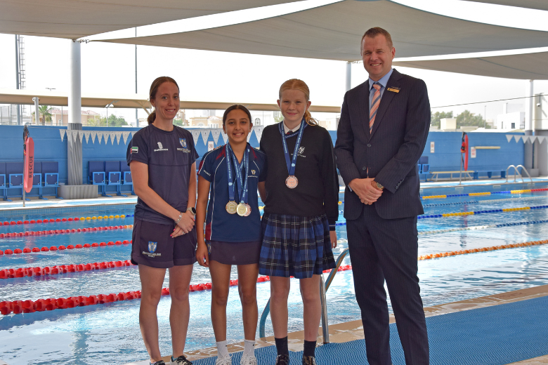 Brighton College Dubai students Aya and Annie with sports director Sarah Harrod and Head Master Simon at the school swimming pool