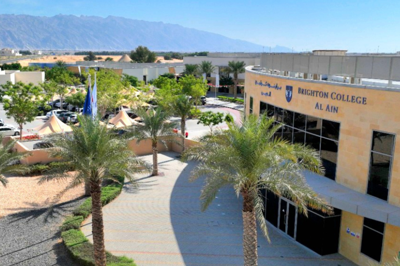 A wide view of Brighton College Al Ain campus showing buildings, trees, and the mountain backdrop.