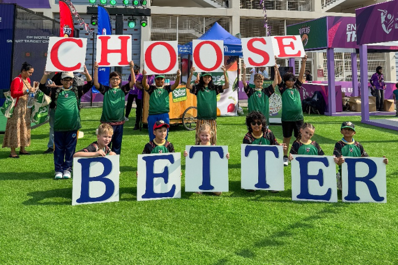 Students from the Desert Vipers Schools Programme hold up signs promoting the 'Choose Better' sustainability campaign in the UAE