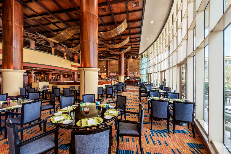 Modern buffet dining area at Al Raha Beach Hotel with floor-to-ceiling windows and elegant seating