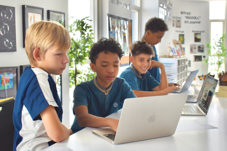 Young Bloom World Academy students collaborating during a hands-on AI learning activity