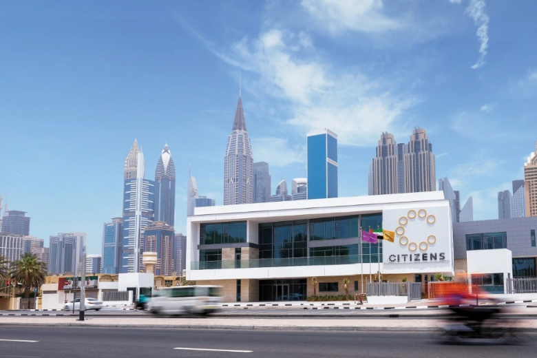 Exterior view of Citizens School campus in Dubai with city skyline backdrop.