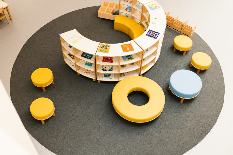 Circular yellow and white school library bookshelf designed for collaborative learning