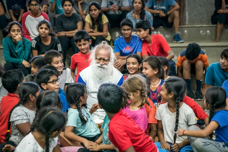 Sadhguru surrounded by students during a joyful moment at Isha Home School