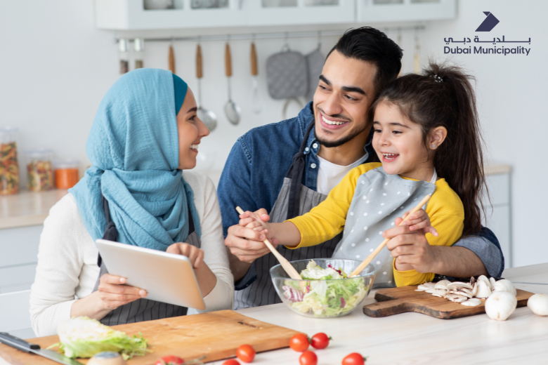 Family cooking healthy food together at home with Dubai Municipality logo
