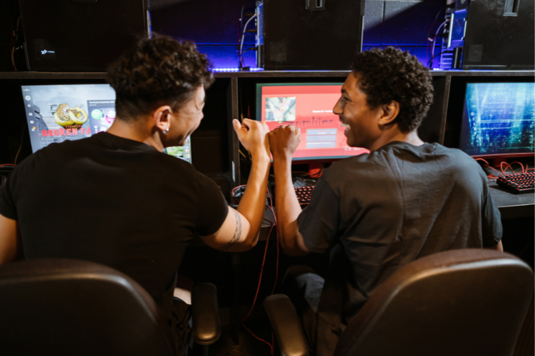 Two esports players celebrating teamwork at a gaming competition.