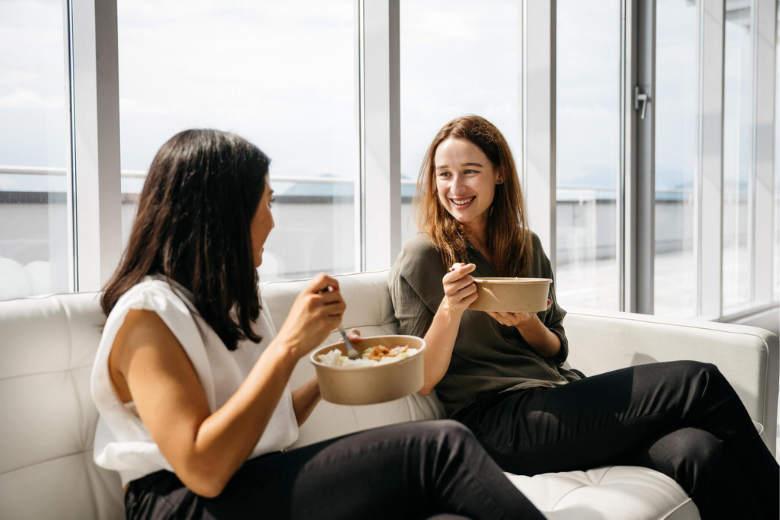 Friends sharing nutritious Meals on Me bowls in a bright setting, highlighting fresh and balanced ingredients