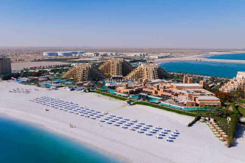 Aerial view of Rixos Bab Al Bahr resort and private white sandy beach on Al Marjan Island.