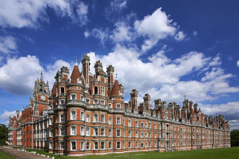 Royal Holloway University of London exterior view showcasing historic Victorian architecture under a blue sky