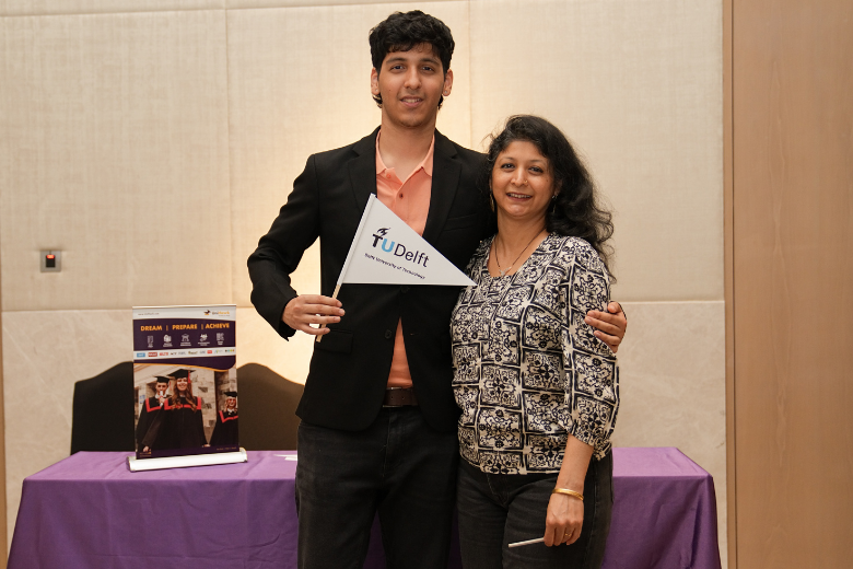 UniHawk student holding TU Delft flag after securing admission to study aerospace engineering in the Netherlands.