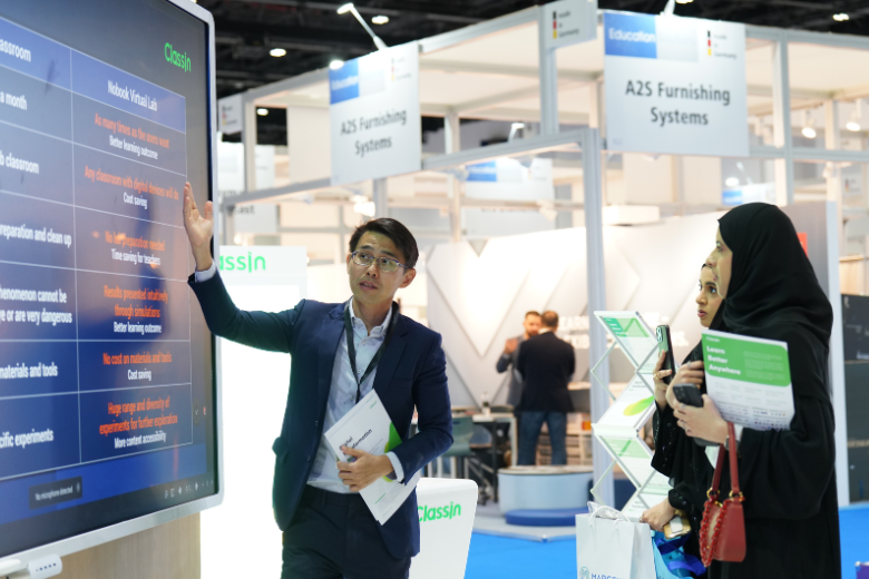Attendee pointing at a screen during GESS Dubai 2025 exhibition, highlighting education technology and networking.