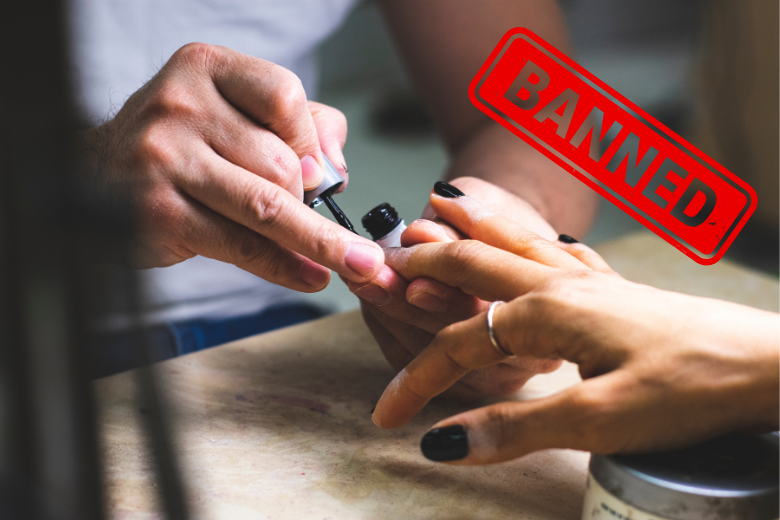 Close-up of hands applying nail polish with “banned” label, showing UAE school appearance guidelines.