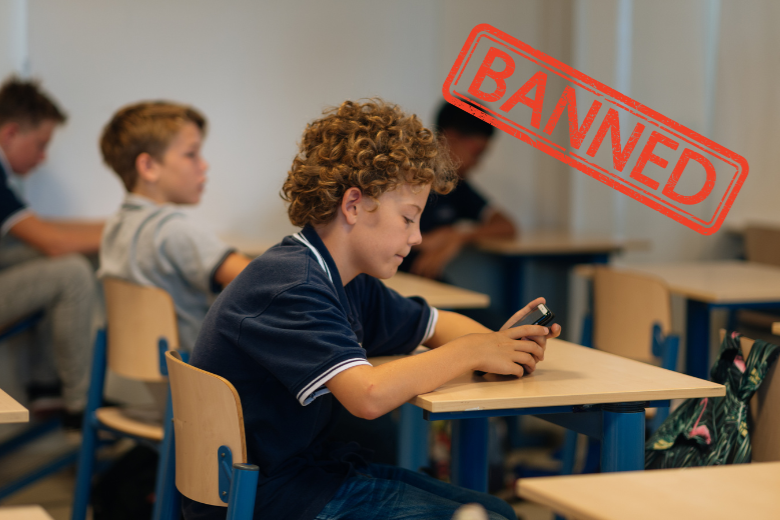 Student in classroom using phone with “Banned” label under UAE school smartphone policy.