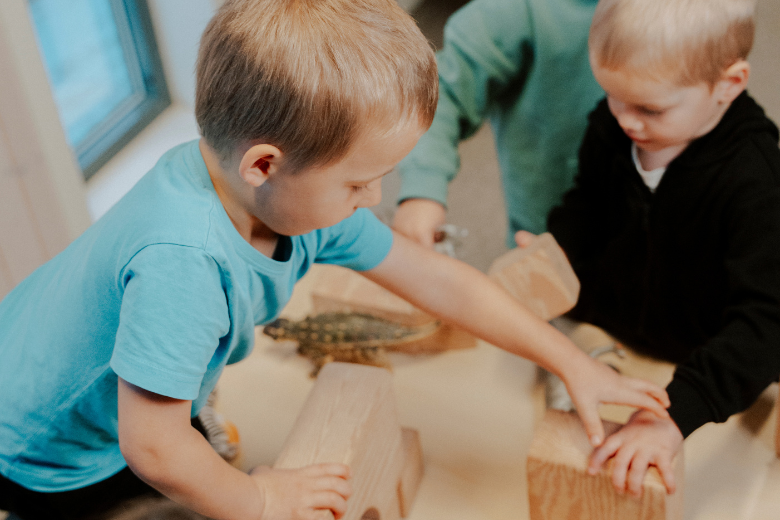 Young children at Dibber International Nurseries playing with wooden blocks to develop problem-solving and motor skills