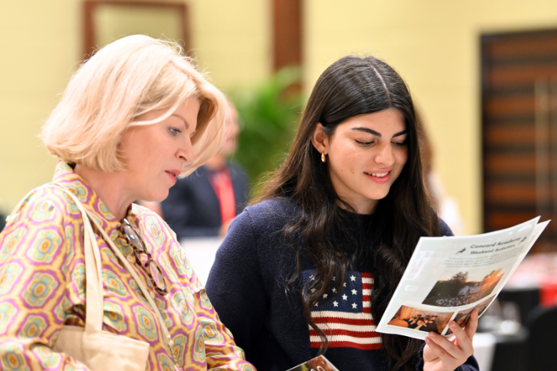Parent and student reviewing US boarding school brochures at the Sesameed Dubai fair