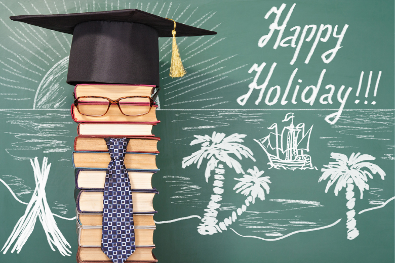 tack of books with a graduation cap in front of a chalkboard reading “Happy Holiday,” symbolising balance between study and rest.