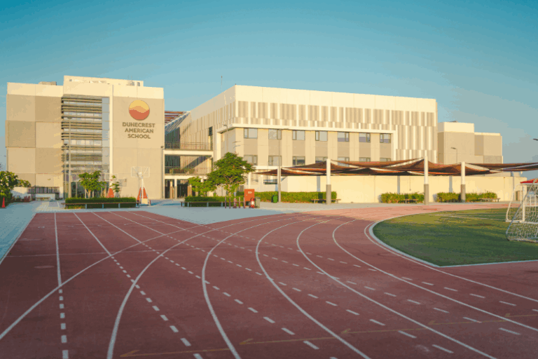 Exterior view of Dunecrest American School campus with athletics track and modern facilities