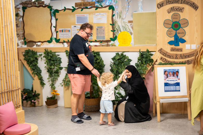 A teacher and parent at JINS ECC in Dubai greeting a young child in a warm, play-based learning environment that celebrates Arabic language and culture.