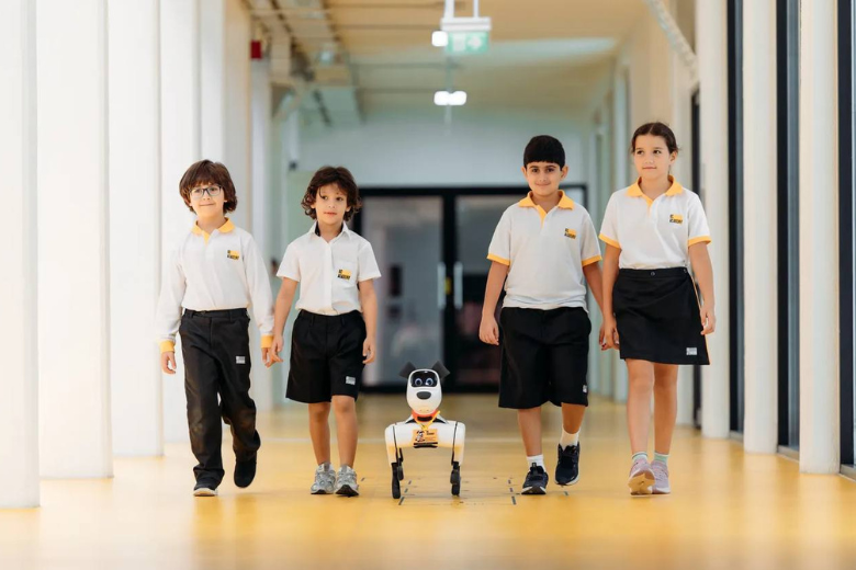 BC Academy students walking in a school corridor with a friendly learning robot