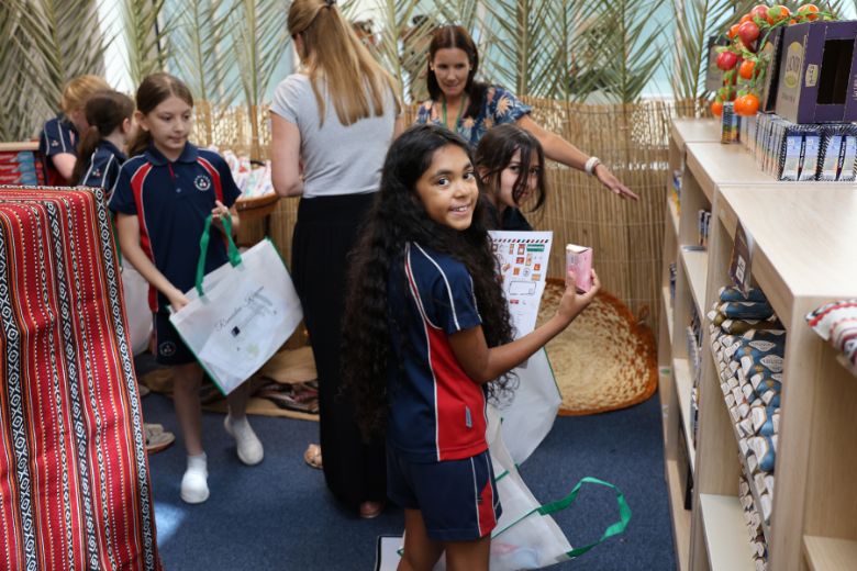 Pupils learning about Ramadan traditions while assembling charity care packages during school Souk event