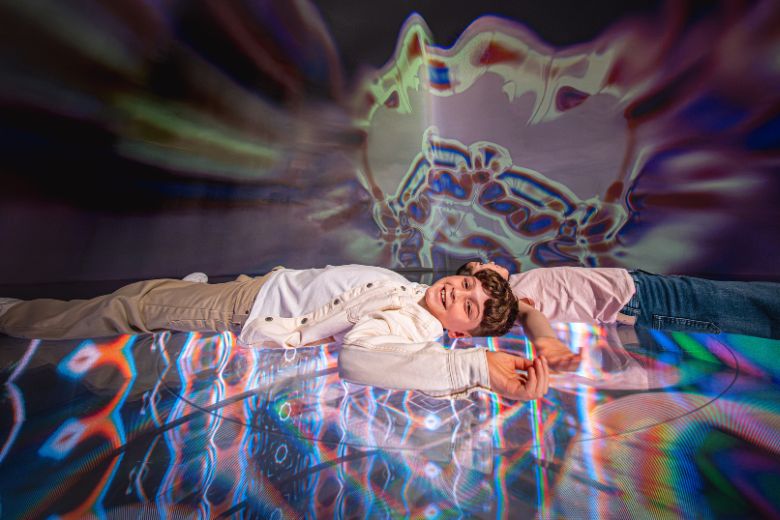 Kids experiencing colourful light projections during Eid at AYA Universe