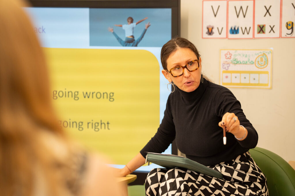Nursery teacher interacting warmly with young child in classroom