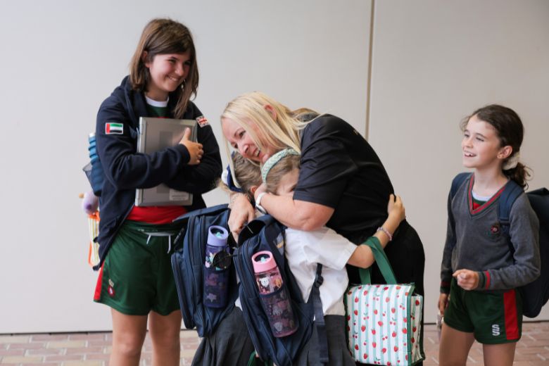 School staff welcoming children at the entrance during morning arrival