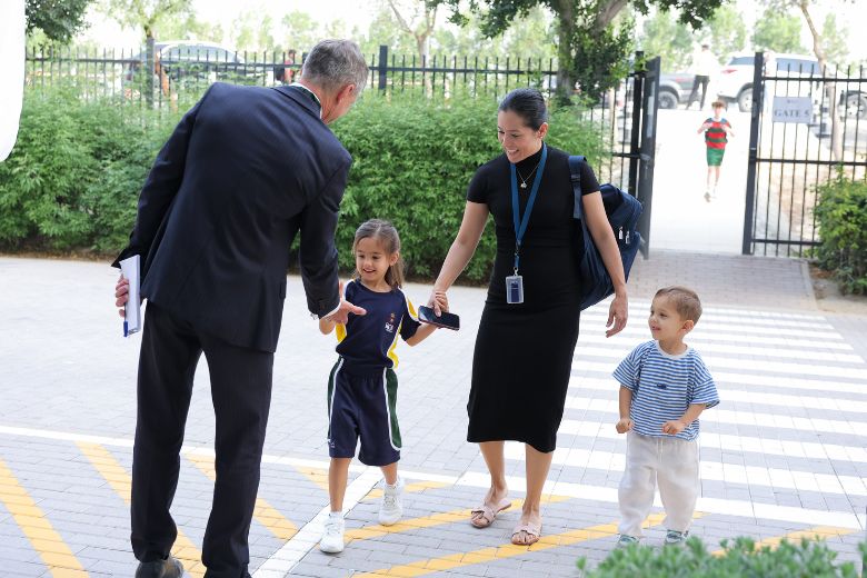 Students returning to school campus greeted by teachers and staff