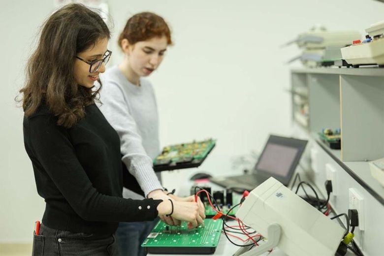 Engineering students at AURAK studying robotics and electrical systems in a laboratory