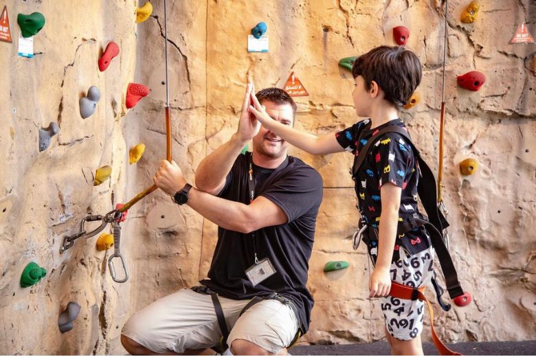 Families taking part in indoor adventure activities including climbing, jumping and obstacle challenges in an energetic play zone