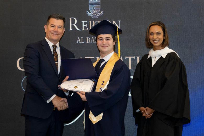 Cognita UAE Managing Director Glen Radojkovich and Repton Al Barsha Principal Chandini Misra present an award to Head Boy Iasonas Romanos during the inaugural A-Level graduation ceremony
