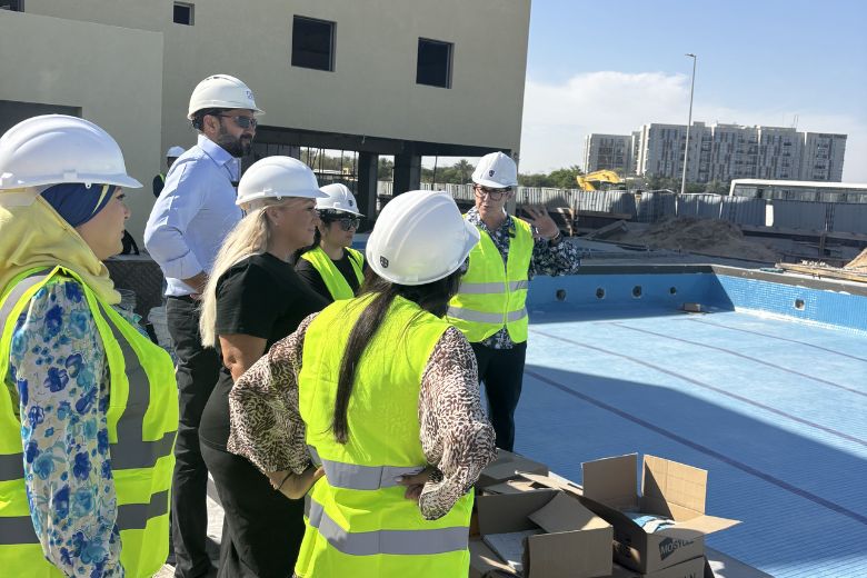 Principal Abigail Fishbourne leads the group around the pool terrace, one of several completed facilities that will be ready and in use from the first day of term