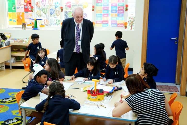 Principal Roger McDuff celebrates student achievement and school spirit alongside students at ICS Al Danah