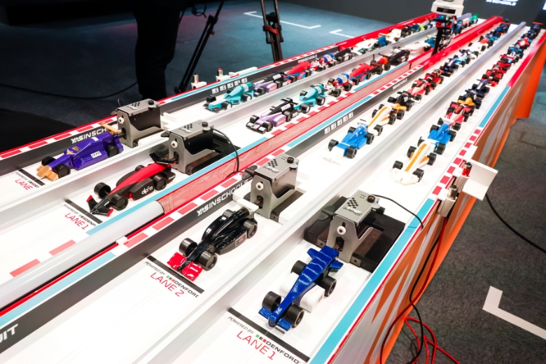 A student team proudly displays their custom-designed motorsport branding and technical portfolio
